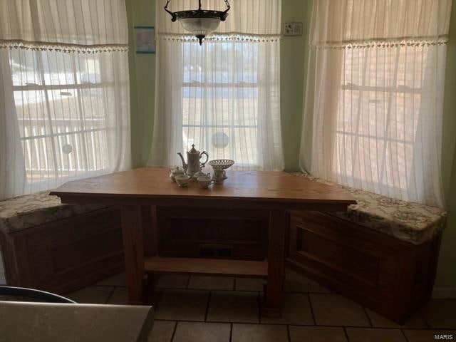 dining area featuring dark tile flooring and a healthy amount of sunlight