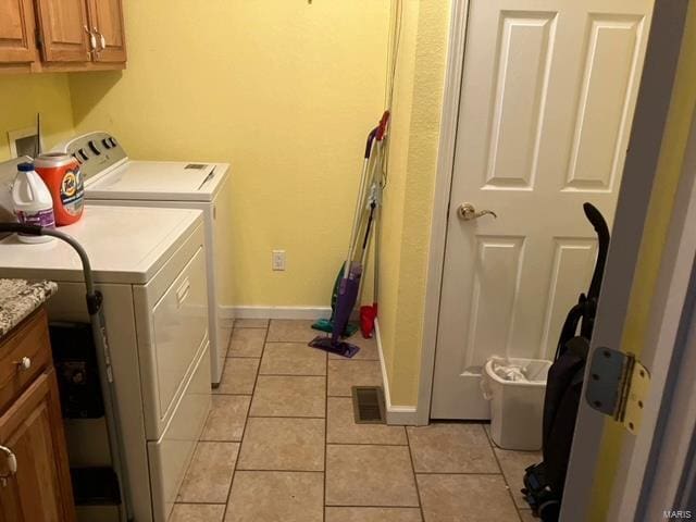 laundry room with light tile flooring, washer hookup, separate washer and dryer, and cabinets