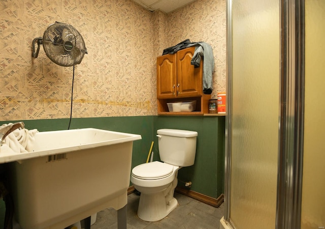 bathroom with a shower with shower door, toilet, and tile floors