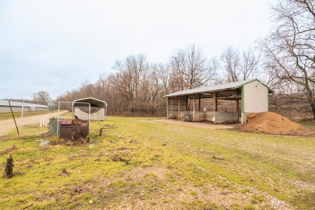 view of yard featuring a carport and an outdoor structure