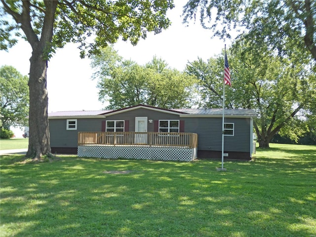 rear view of house with a yard, metal roof, and a wooden deck