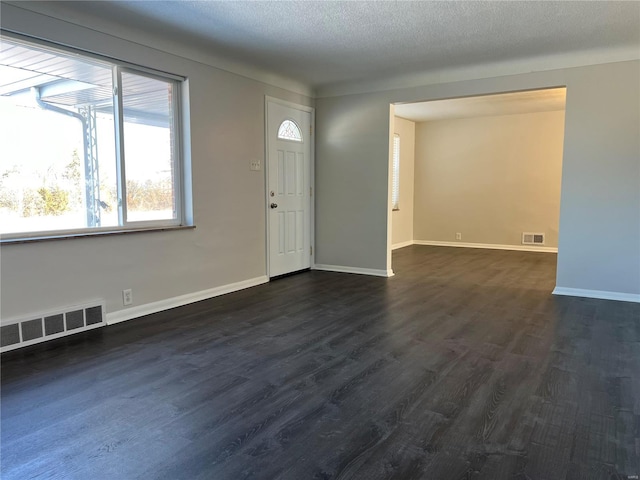 entryway featuring a textured ceiling and dark hardwood / wood-style flooring