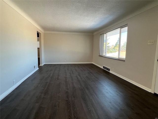 spare room with dark hardwood / wood-style flooring and a textured ceiling