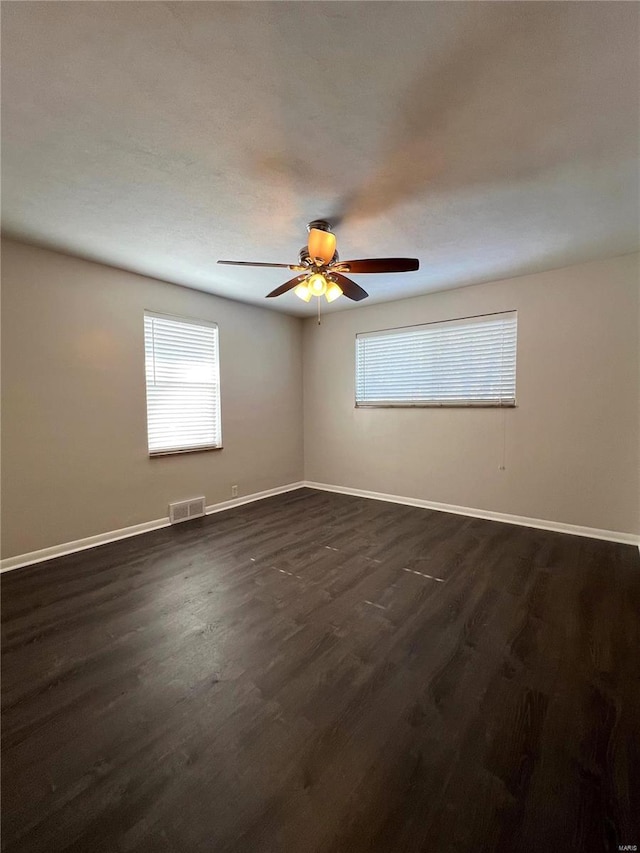 spare room with dark hardwood / wood-style floors and ceiling fan