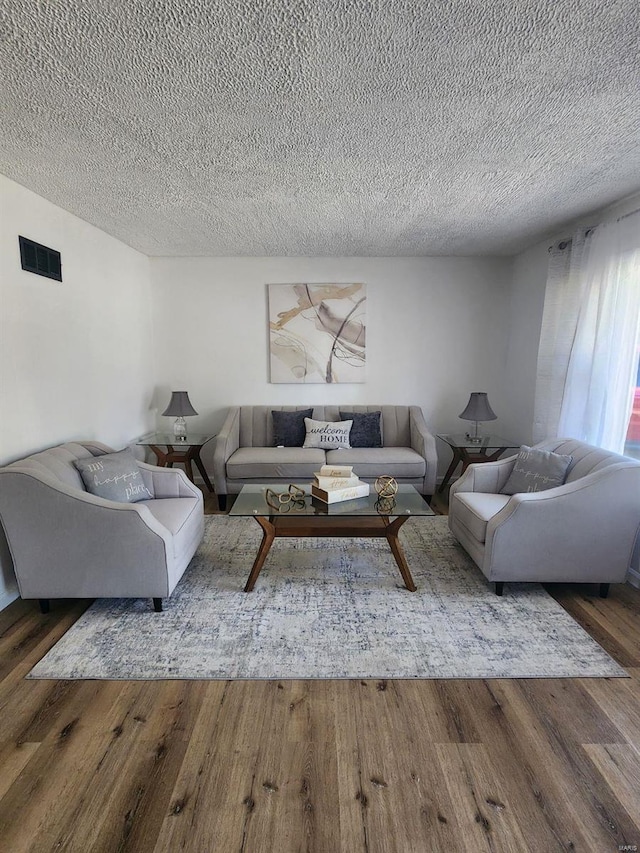 living room featuring hardwood / wood-style floors and a textured ceiling