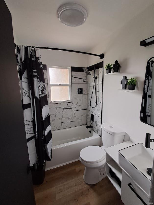 full bathroom with hardwood / wood-style floors, vanity, shower / bath combo, and toilet