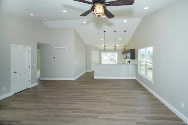 unfurnished living room featuring hardwood / wood-style floors, high vaulted ceiling, and ceiling fan