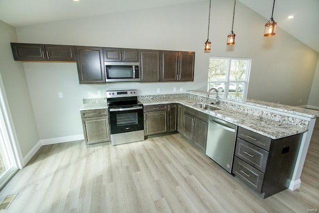 kitchen featuring appliances with stainless steel finishes, high vaulted ceiling, light hardwood / wood-style flooring, sink, and decorative light fixtures