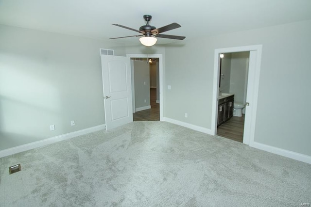 unfurnished bedroom with connected bathroom, carpet flooring, and ceiling fan