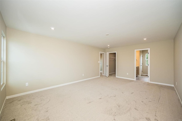 spare room featuring light carpet, baseboards, and recessed lighting