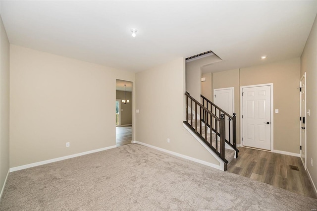 unfurnished room with carpet flooring, stairway, and baseboards