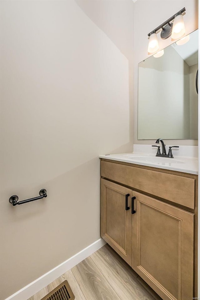 bathroom featuring wood finished floors, vanity, and baseboards