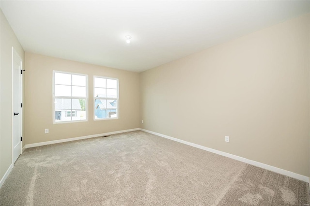 empty room with baseboards and light colored carpet