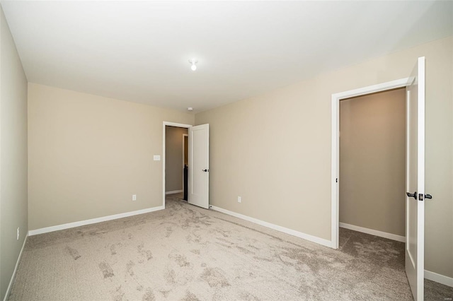 spare room featuring baseboards and light colored carpet