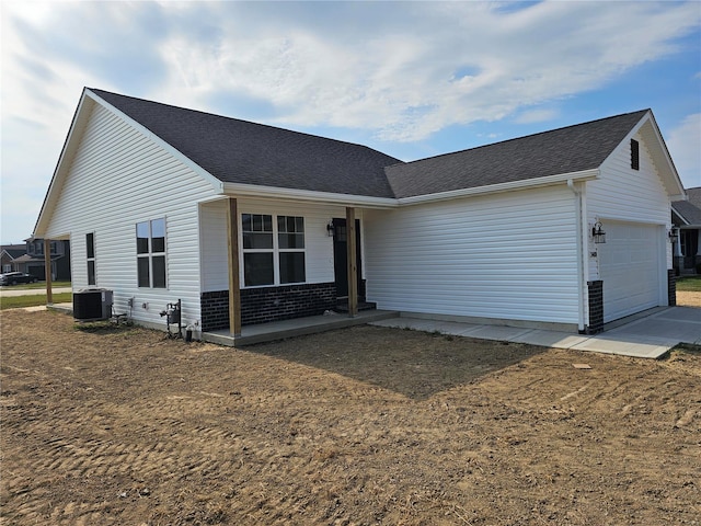 ranch-style home featuring a front yard, a garage, and central air condition unit