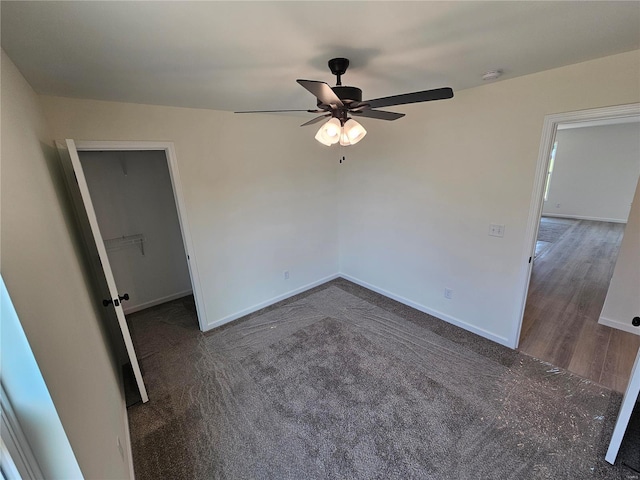 unfurnished room featuring ceiling fan and dark carpet