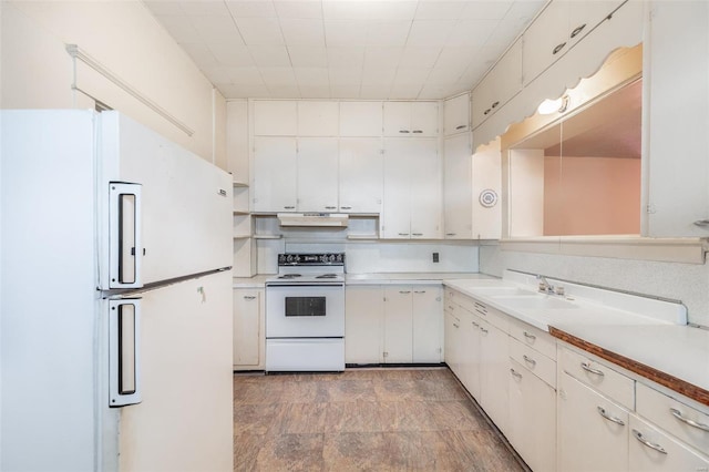 kitchen with white appliances, white cabinetry, light tile floors, and sink