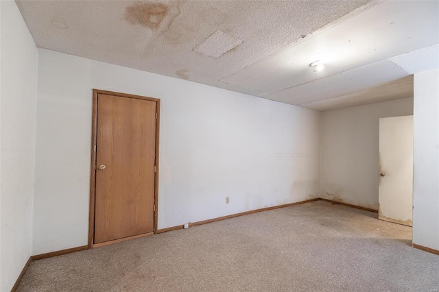 unfurnished room featuring light carpet and a textured ceiling