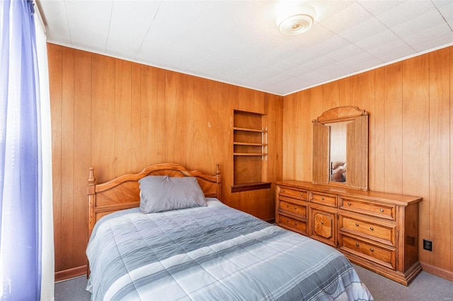 bedroom featuring wooden walls and light carpet