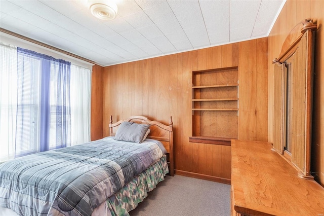 bedroom with light colored carpet, wood walls, and ornamental molding