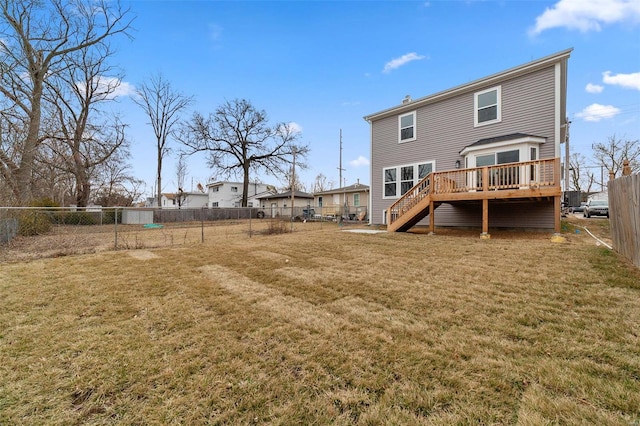 back of house featuring a lawn and a wooden deck