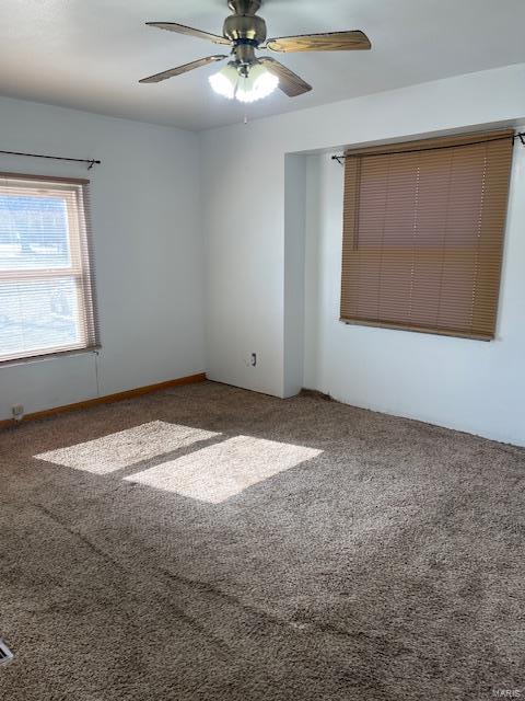 carpeted spare room featuring ceiling fan