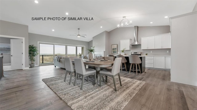 dining space featuring light wood-type flooring, high vaulted ceiling, and ceiling fan with notable chandelier