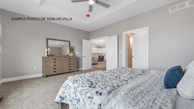 bedroom with ceiling fan, a raised ceiling, and light carpet