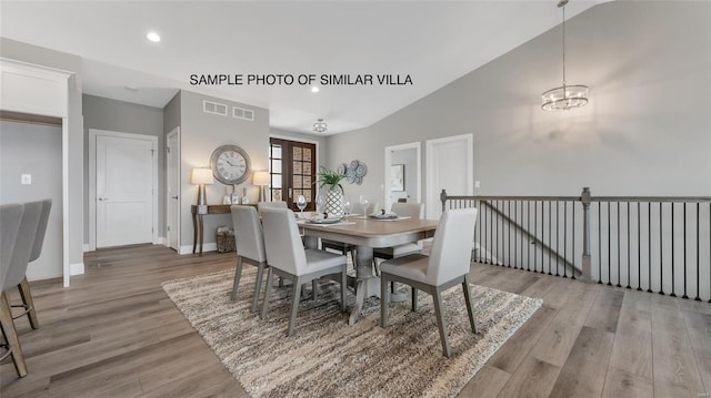 dining space featuring french doors, an inviting chandelier, vaulted ceiling, and light wood-type flooring