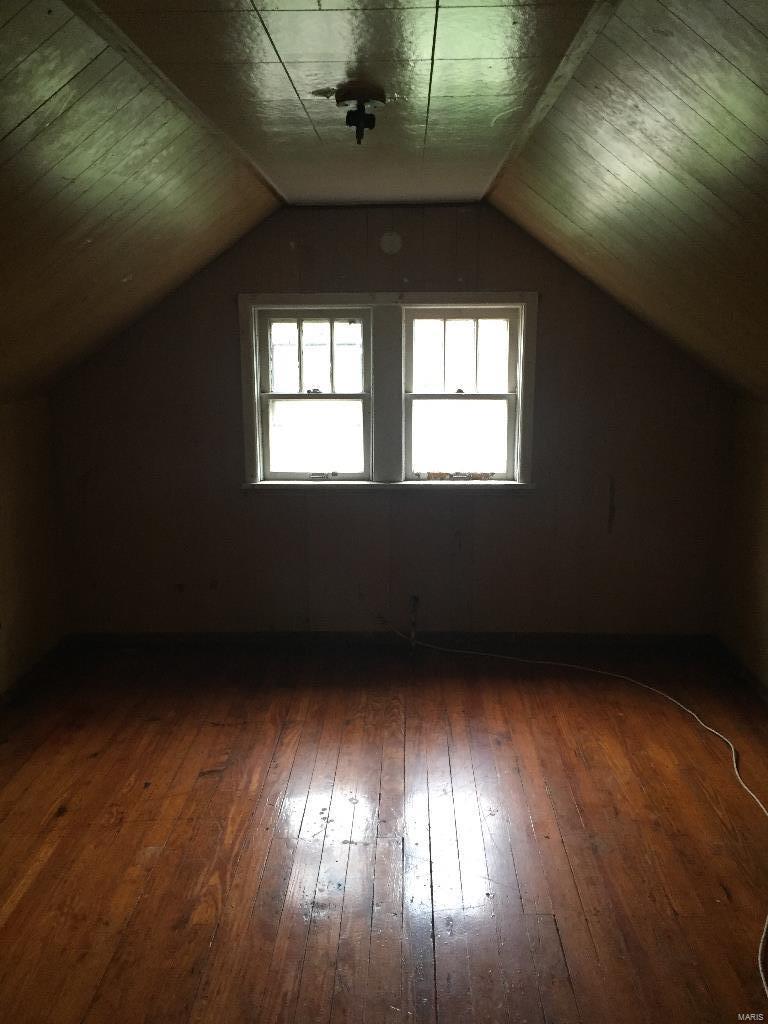 bonus room with lofted ceiling and dark hardwood / wood-style floors