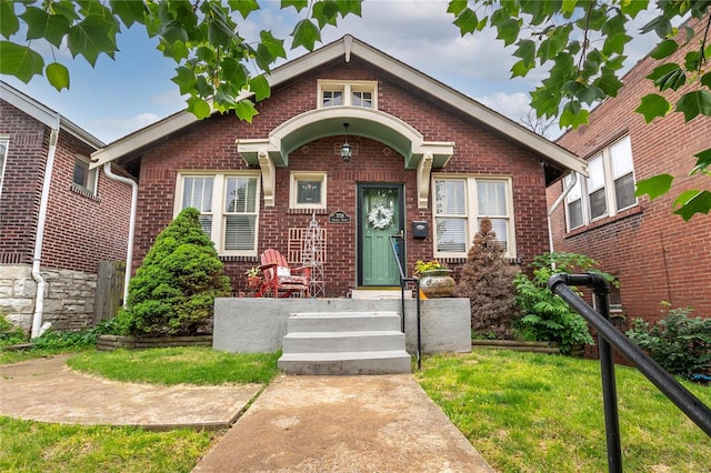 bungalow-style home with a front yard