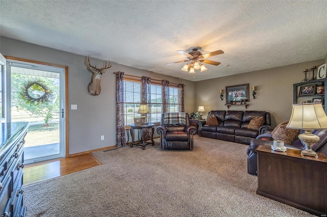 carpeted living room featuring a textured ceiling, ceiling fan, and a wealth of natural light