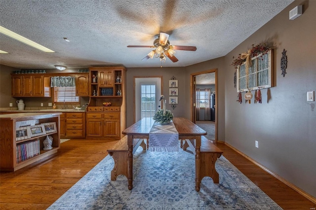 interior space with ceiling fan, light hardwood / wood-style flooring, plenty of natural light, and a textured ceiling