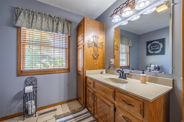 bathroom with tile floors, a textured ceiling, and vanity