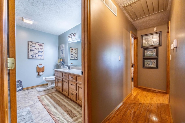 bathroom featuring tile floors, toilet, a textured ceiling, and vanity