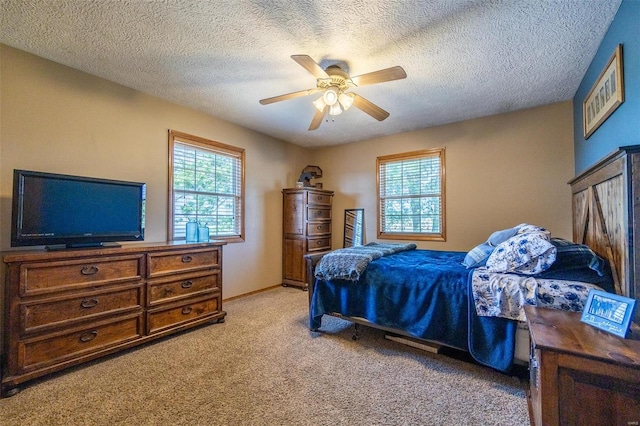 carpeted bedroom with ceiling fan and a textured ceiling