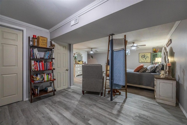 interior space featuring ceiling fan, crown molding, a textured ceiling, and hardwood / wood-style floors