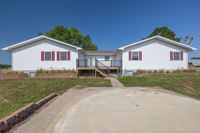 rear view of house with a wooden deck and a yard