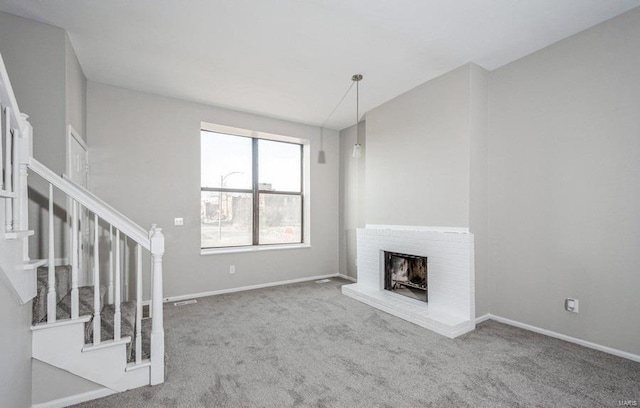 unfurnished living room featuring a brick fireplace and light carpet