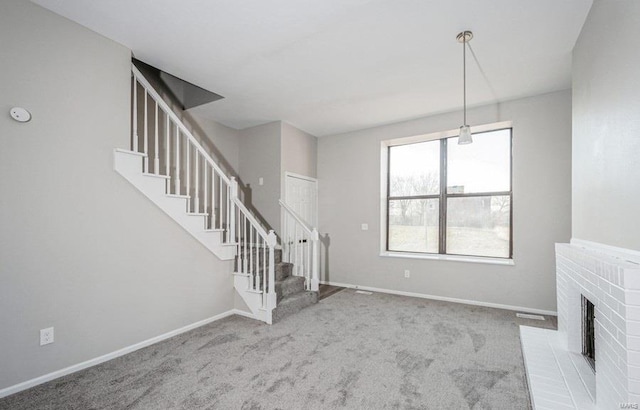 unfurnished living room featuring light carpet and a brick fireplace