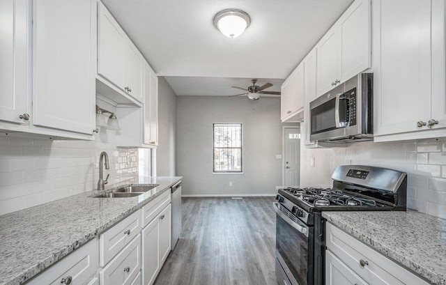 kitchen with ceiling fan, stainless steel appliances, light hardwood / wood-style floors, sink, and white cabinets