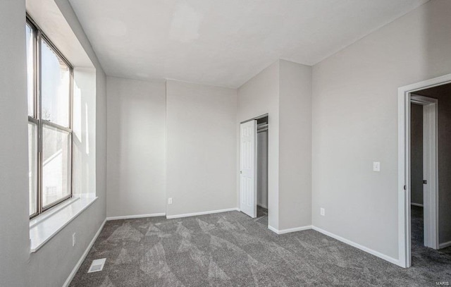 empty room with dark carpet and a wealth of natural light