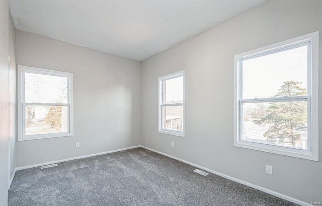 unfurnished room with dark carpet