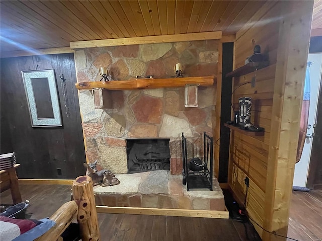 living room with wood-type flooring, a fireplace, wooden walls, and wood ceiling