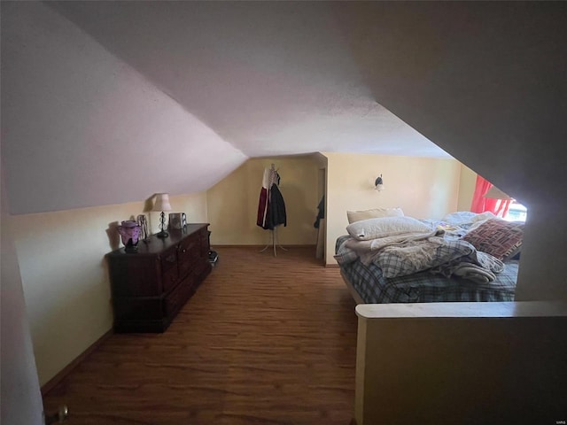 bedroom with vaulted ceiling and dark wood-type flooring