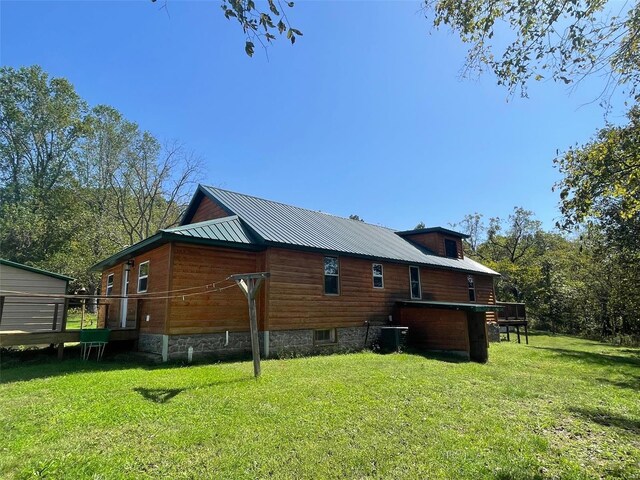 back of property with a yard and central AC