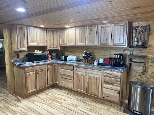 kitchen with light hardwood / wood-style floors, wooden walls, and light brown cabinetry