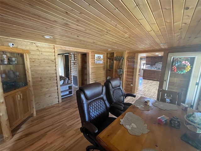 office with wooden walls, a fireplace, light hardwood / wood-style floors, and wooden ceiling