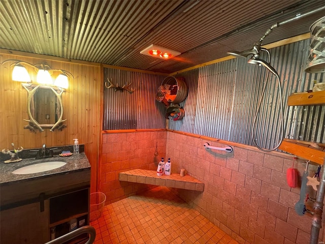 bathroom with tile walls, tile patterned floors, ceiling fan, and vanity