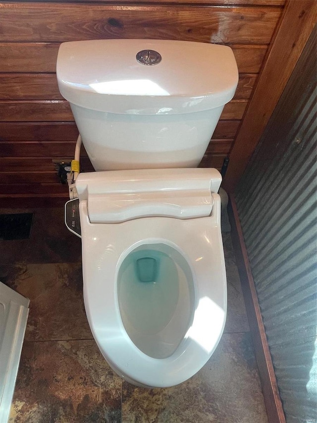 interior details featuring wood walls and toilet